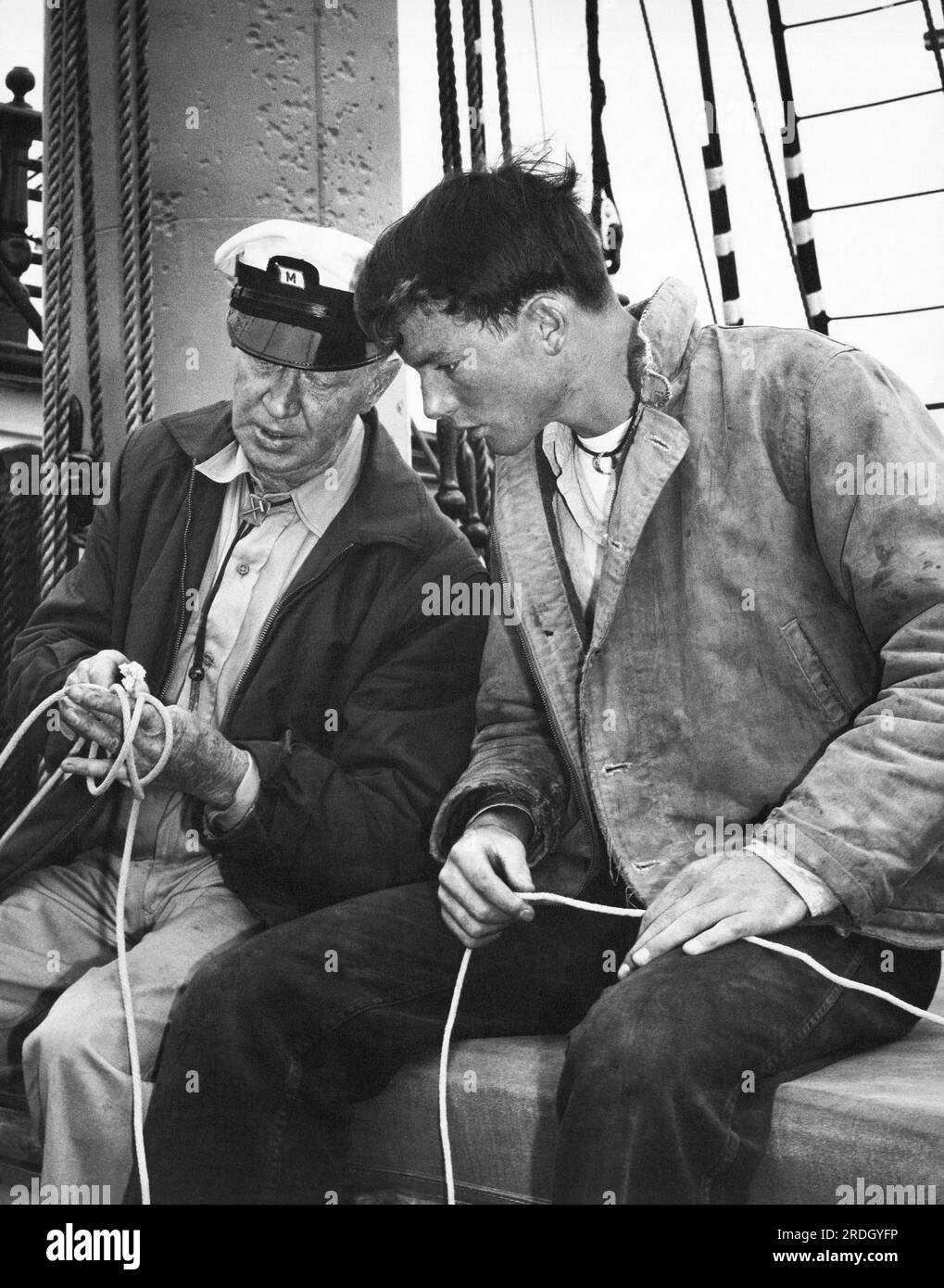 San Francisco, California: c. 1962 un vecchio marinaio dà a un giovane lezioni di legatura dei nodi. Foto Stock