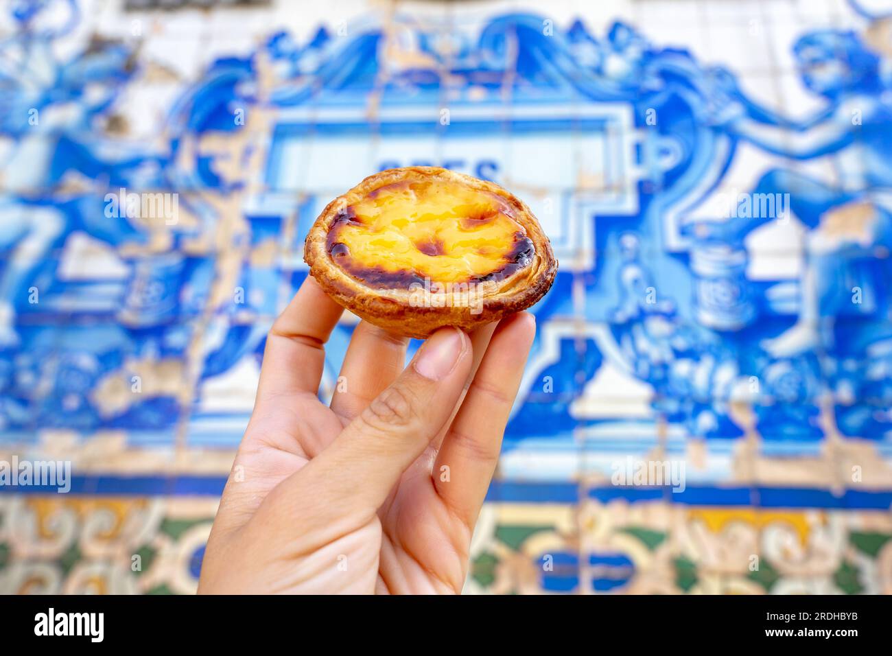 Tenendo pastel de nata a Porto Portogallo davanti a bellissime piastrelle blu azulejo bianche . Foto Stock