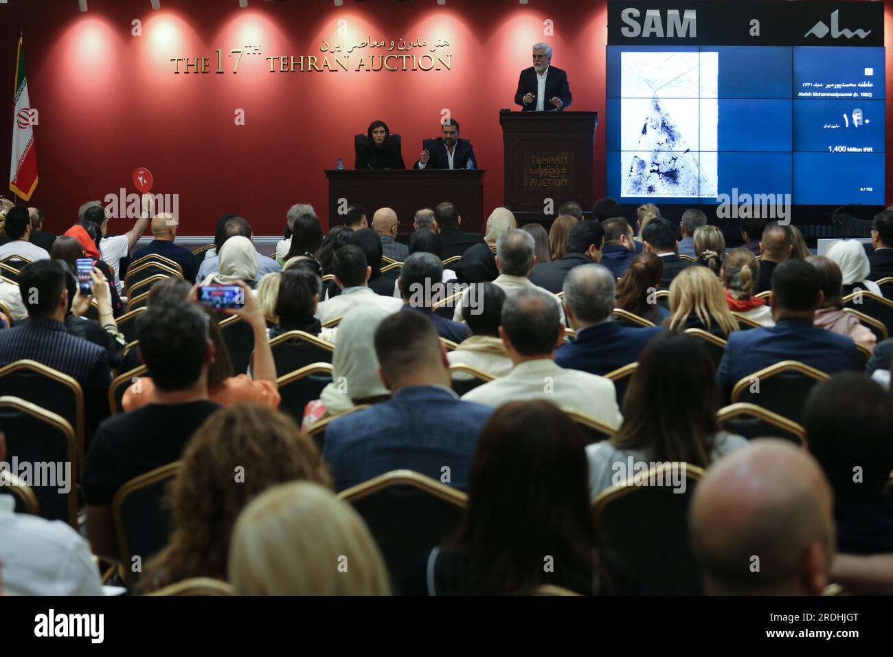 Teheran, Iran. 21 luglio 2023. I partecipanti seguono la diciassettesima asta d'arte iraniana moderna e contemporanea di Teheran mentre il banditore d'asta, Hossein Pakdel (C), è visto al Parsian Azadi Hotel. Teheran Auction è stata lanciata nel 2012 come un'iniziativa indipendente e privata per introdurre l'arte iraniana che va da artisti iraniani affermati ed emergenti a collezionisti d'arte iraniani e a un pubblico globale. Essa mira a sostenere il mercato dell'arte nazionale come base fondamentale per il mercato internazionale. (Immagine di credito: © Rouzbeh Fouladi/ZUMA Press Wire) SOLO USO EDITORIALE! Non per USO commerciale! Foto Stock