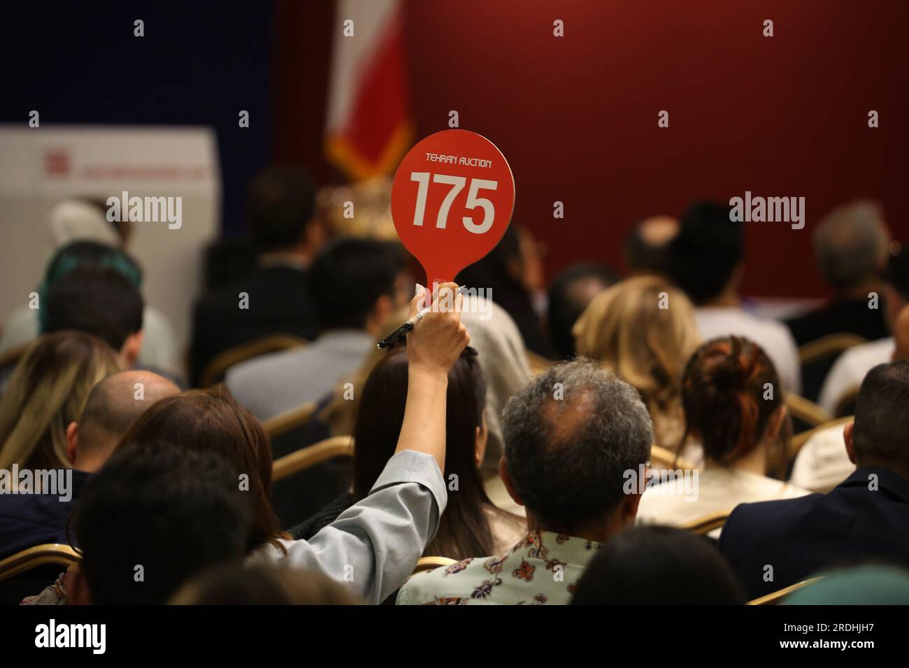 Teheran, Iran. 21 luglio 2023. Una donna iraniana solleva il suo segno d'offerta alla 17a asta d'arte iraniana moderna e contemporanea di Teheran presso il Parsian Azadi Hotel. Teheran Auction è stata lanciata nel 2012 come un'iniziativa indipendente e privata per introdurre l'arte iraniana che va da artisti iraniani affermati ed emergenti a collezionisti d'arte iraniani e a un pubblico globale. Essa mira a sostenere il mercato dell'arte nazionale come base fondamentale per il mercato internazionale. (Immagine di credito: © Rouzbeh Fouladi/ZUMA Press Wire) SOLO USO EDITORIALE! Non per USO commerciale! Foto Stock