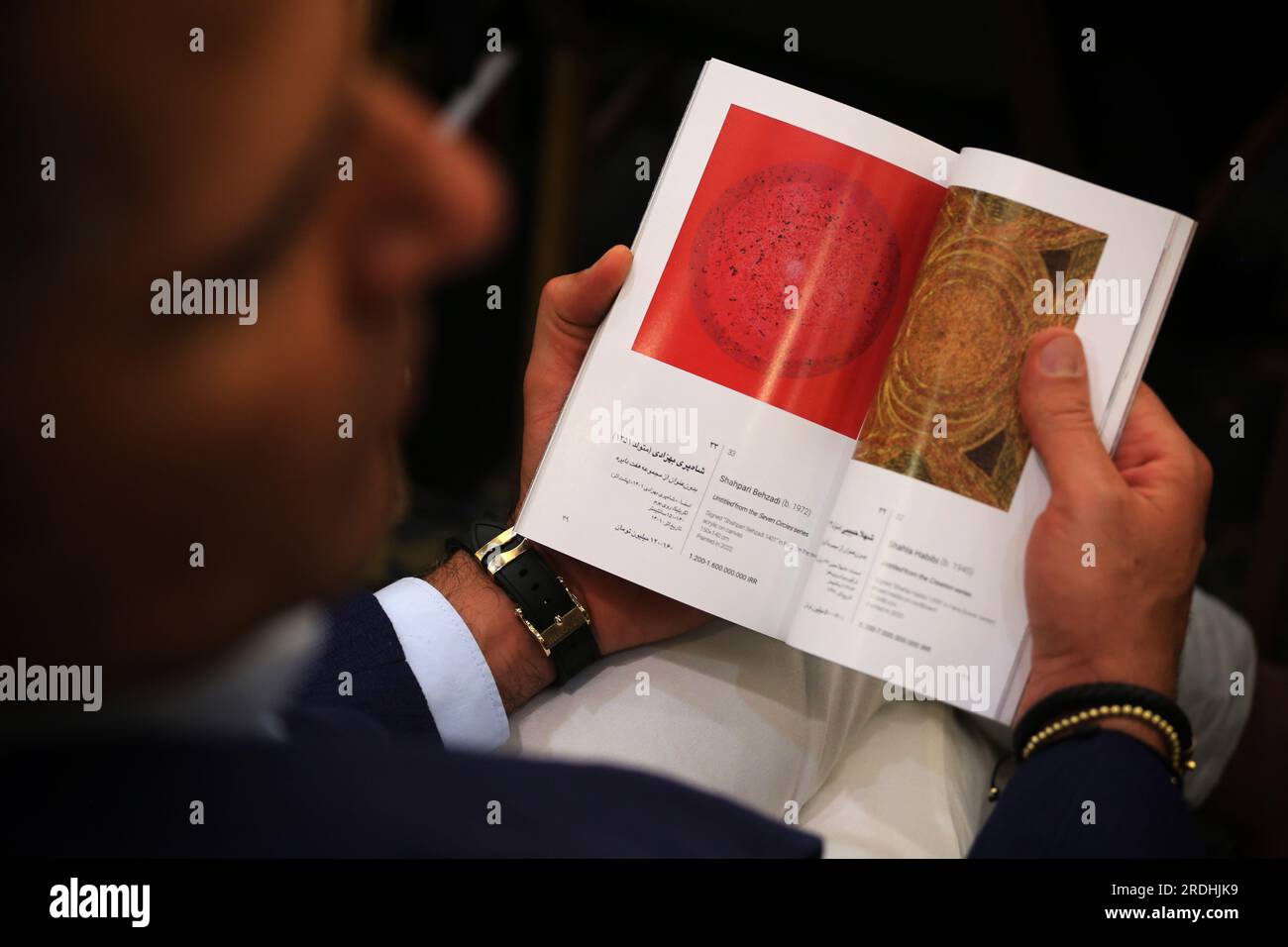 Teheran, Iran. 21 luglio 2023. Un maschio iraniano recensisce la brochure della 17a asta d'arte iraniana moderna e contemporanea di Teheran presso il Parsian Azadi Hotel. Teheran Auction è stata lanciata nel 2012 come un'iniziativa indipendente e privata per introdurre l'arte iraniana che va da artisti iraniani affermati ed emergenti a collezionisti d'arte iraniani e a un pubblico globale. Essa mira a sostenere il mercato dell'arte nazionale come base fondamentale per il mercato internazionale. (Immagine di credito: © Rouzbeh Fouladi/ZUMA Press Wire) SOLO USO EDITORIALE! Non per USO commerciale! Foto Stock