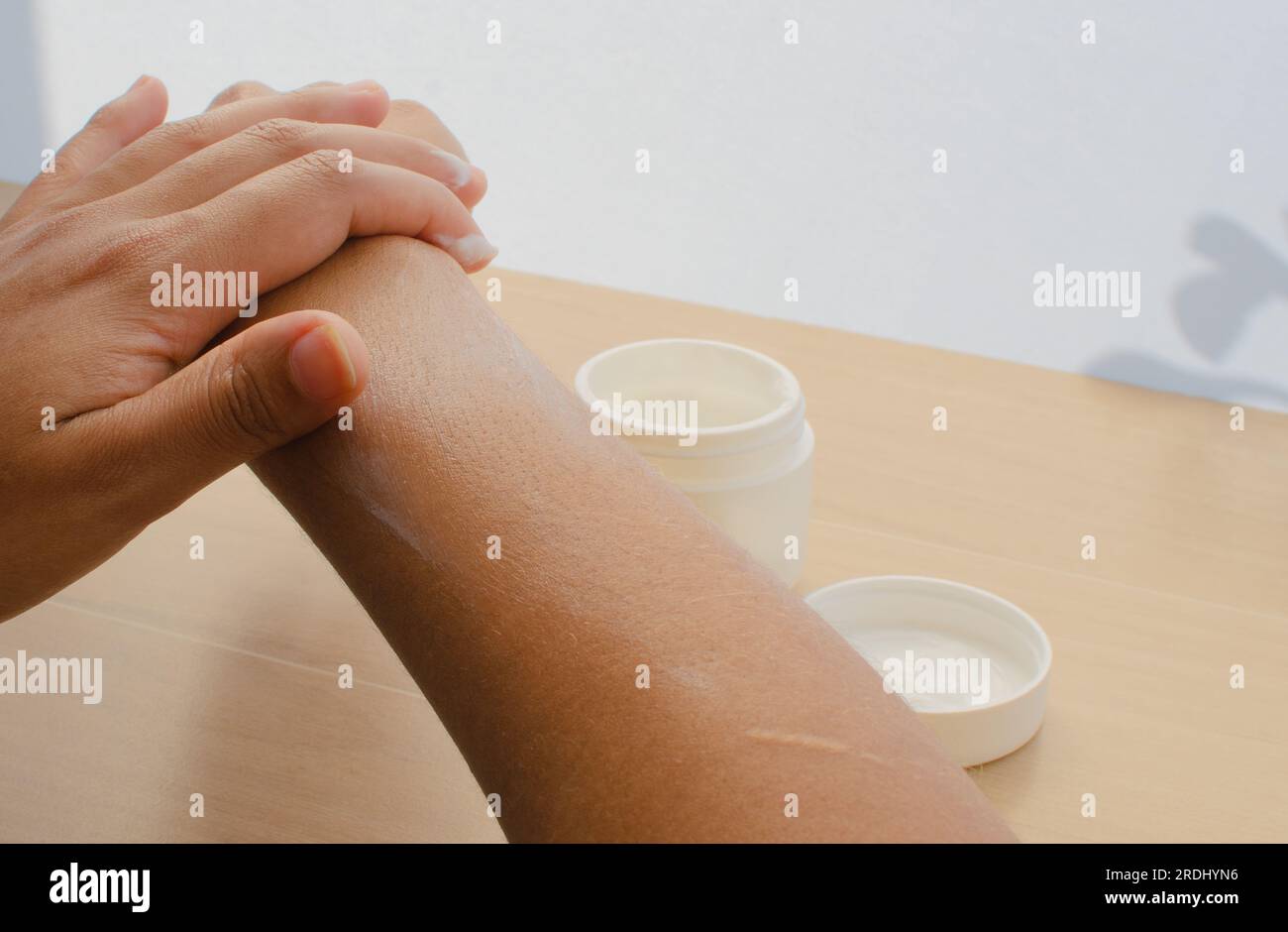 Pelle radiosa: Mani femminili che si prendono cura della pelle con una crema idratante per mantenerla nutriente e bella. Foto Stock