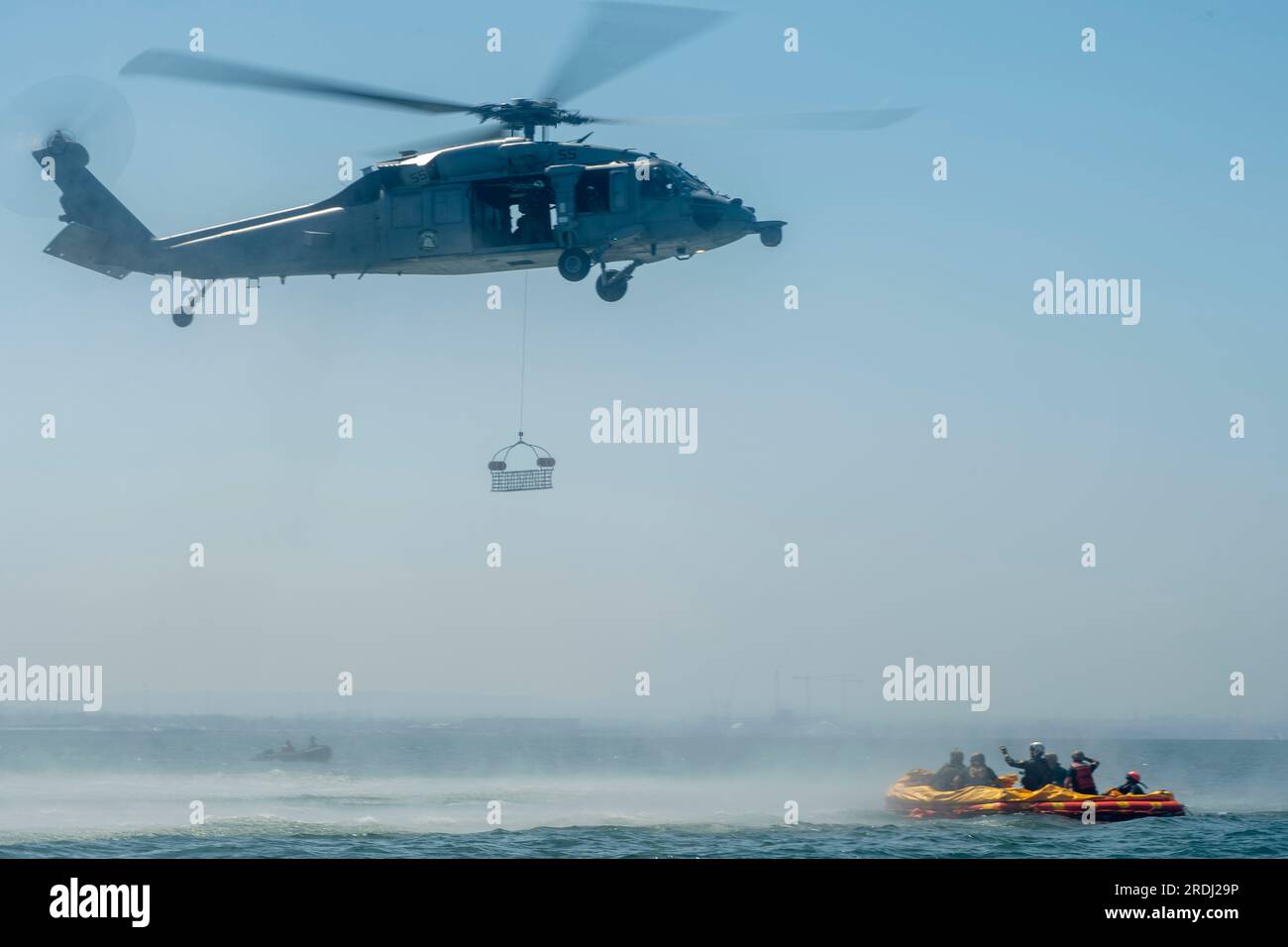 I marinai assegnati all'Helicopter Sea Combat Squadron 23 “wildcards” aspettano un cesto di recupero da un MH-60S Seahawk durante un addestramento di recupero in mare nella baia di San Diego insieme alla NASA per il programma Artemis. In preparazione alla missione con equipaggio della NASA Artemis II, che manderà quattro astronauti in Orion oltre la Luna, NASA e Stati Uniti La Marina condurrà una serie di test per dimostrare e valutare i processi, le procedure e l'hardware utilizzati nelle operazioni di recupero per le missioni lunari con equipaggio. Negli Stati Uniti La Marina ha molte capacità uniche che la rendono un partner ideale per sostenere la NASA, incluso io Foto Stock