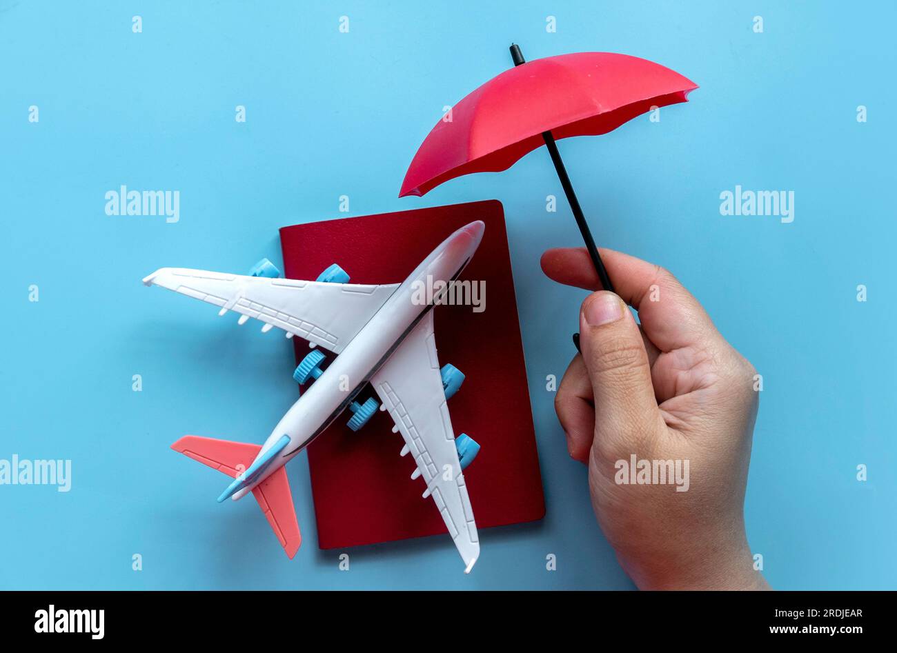 Concetto di assicurazione di viaggio.viaggio di sicurezza. Copertura di ritardi di volo, cancellazione, danni o perdite di valigia, incidenti e spese mediche sanitarie. Red umbrell Foto Stock