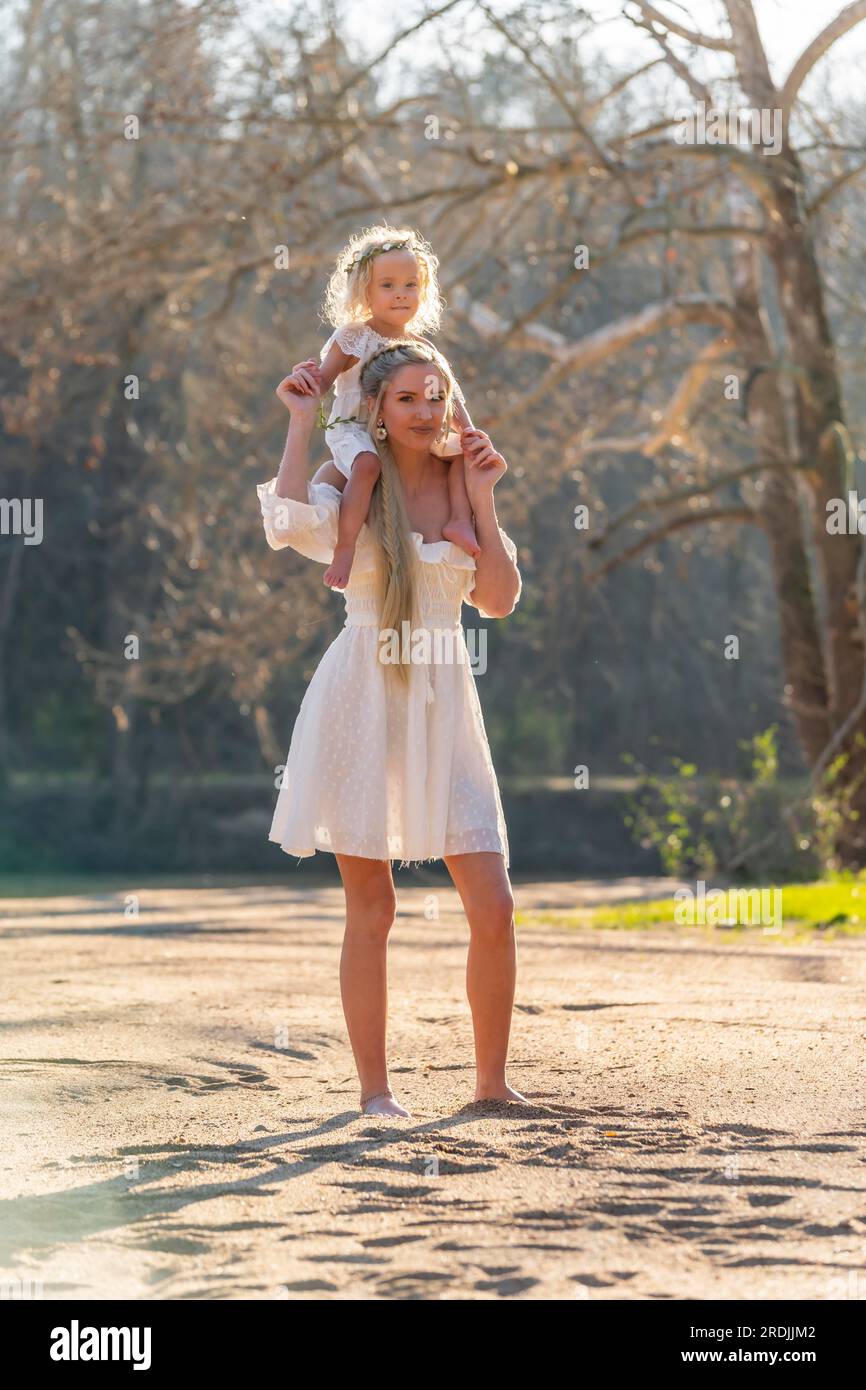 Una giovane madre bellissima e sua figlia godono del clima primaverile Foto Stock