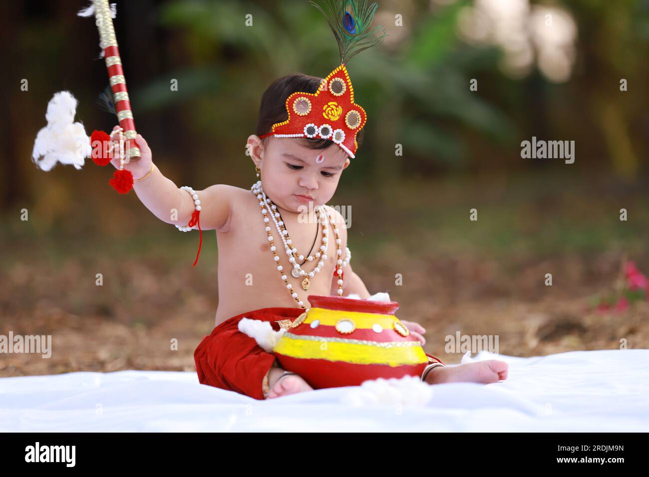 Felice Janmashtami , piccolo ragazzo indiano che posa come Shri Krishna o kanha o kanhaiya con foto di Dahi Handi Foto Stock