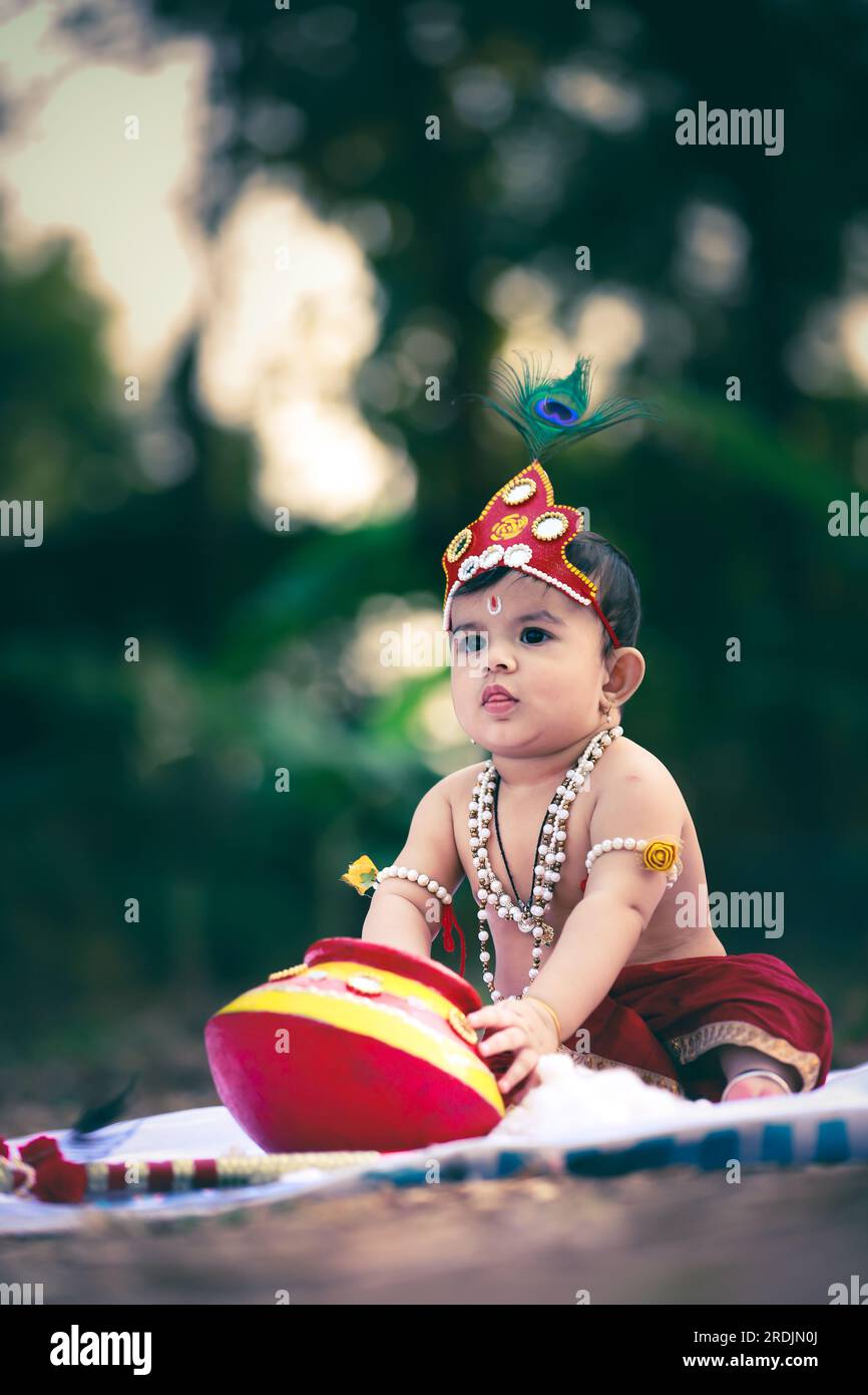 Felice Janmashtami , piccolo ragazzo indiano che posa come Shri Krishna o kanha o kanhaiya con foto di Dahi Handi Foto Stock