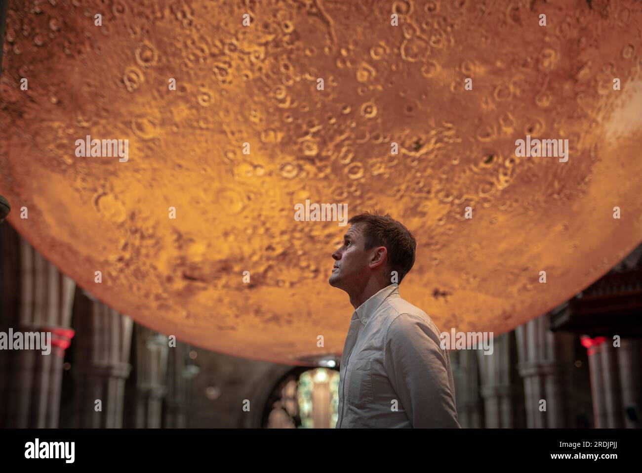 Londra, Regno Unito. 21 luglio 2023. Mars: War & Peace di Luke Jerram (foto). Una replica rotante di sette metri di larghezza su marte di Luke Jerram attualmente in mostra presso la chiesa di San Giovanni Battista. La monumentale scultura sospesa e illuminata internamente è stata costruita utilizzando immagini della NASA con immagini dettagliate a 120 dpi della superficie marziana. A circa un milione di volte più piccolo del pianeta reale, ogni centimetro della scultura sferica rappresenta 10 chilometri della superficie di Marte. Crediti: Guy Corbishley/Alamy Live News Foto Stock