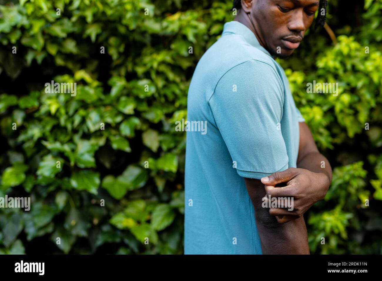 Uomo afro-americano che indossa una polo blu pallido in giardino, spazio fotocopie Foto Stock