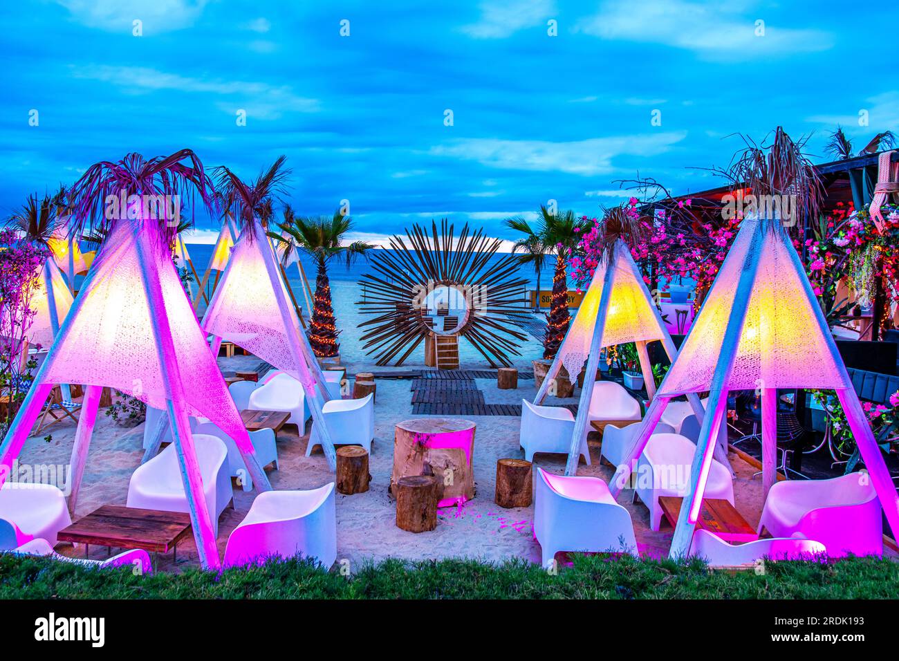 Espinho, Porto, Portogallo - 19 giugno 2023: Scena notturna sulla spiaggia con terrazza ristorante con sedie, tavoli e ombrelloni colorati decorativi a b Foto Stock