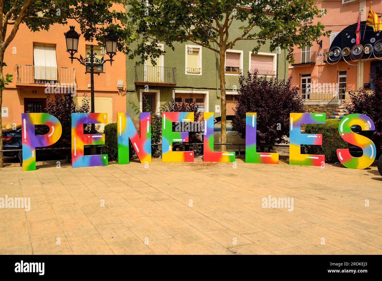 Piazza principale di Penelles con un segno del nome della città e un trattore dipinto (la Noguera, Lleida, Catalogna, Spagna). Esempio: Plaza Mayor de Penelles Foto Stock