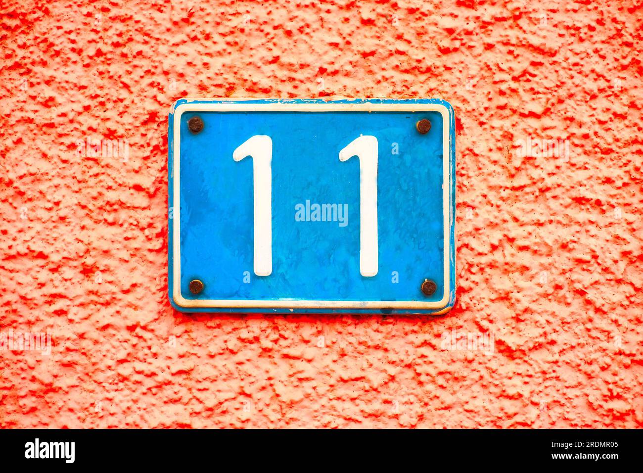 Numero 11, undici, blu su sfondo rosa. Foto Stock
