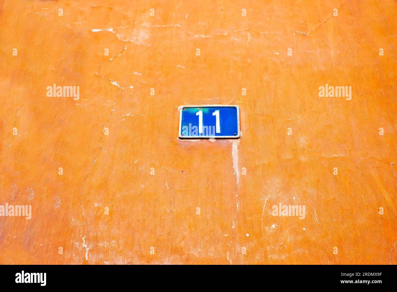Beautifll numero 11, undici, piatto blu su un bellissimo sfondo arancio vecchio e grintoso. Foto Stock