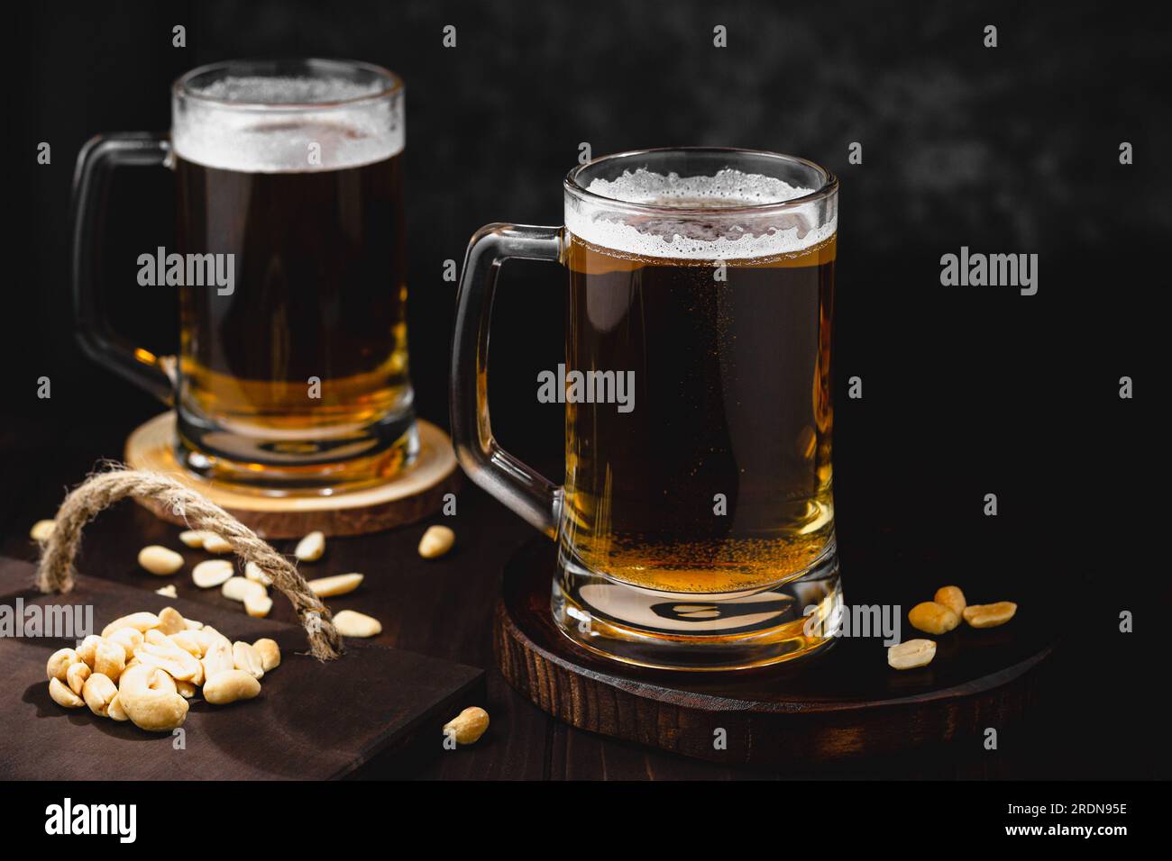 Tazze di birra lager e noci salate. atmosfera dell'oktoberfest, sfondo di birreria artigianale Foto Stock