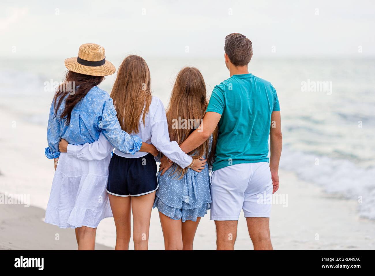 I genitori con due bambini si divertono insieme sulla spiaggia Foto Stock