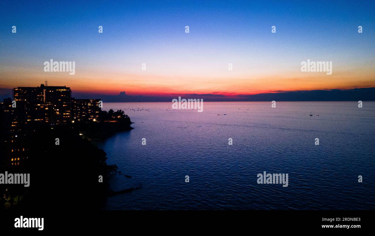 Skyline della città costale al tramonto Foto Stock