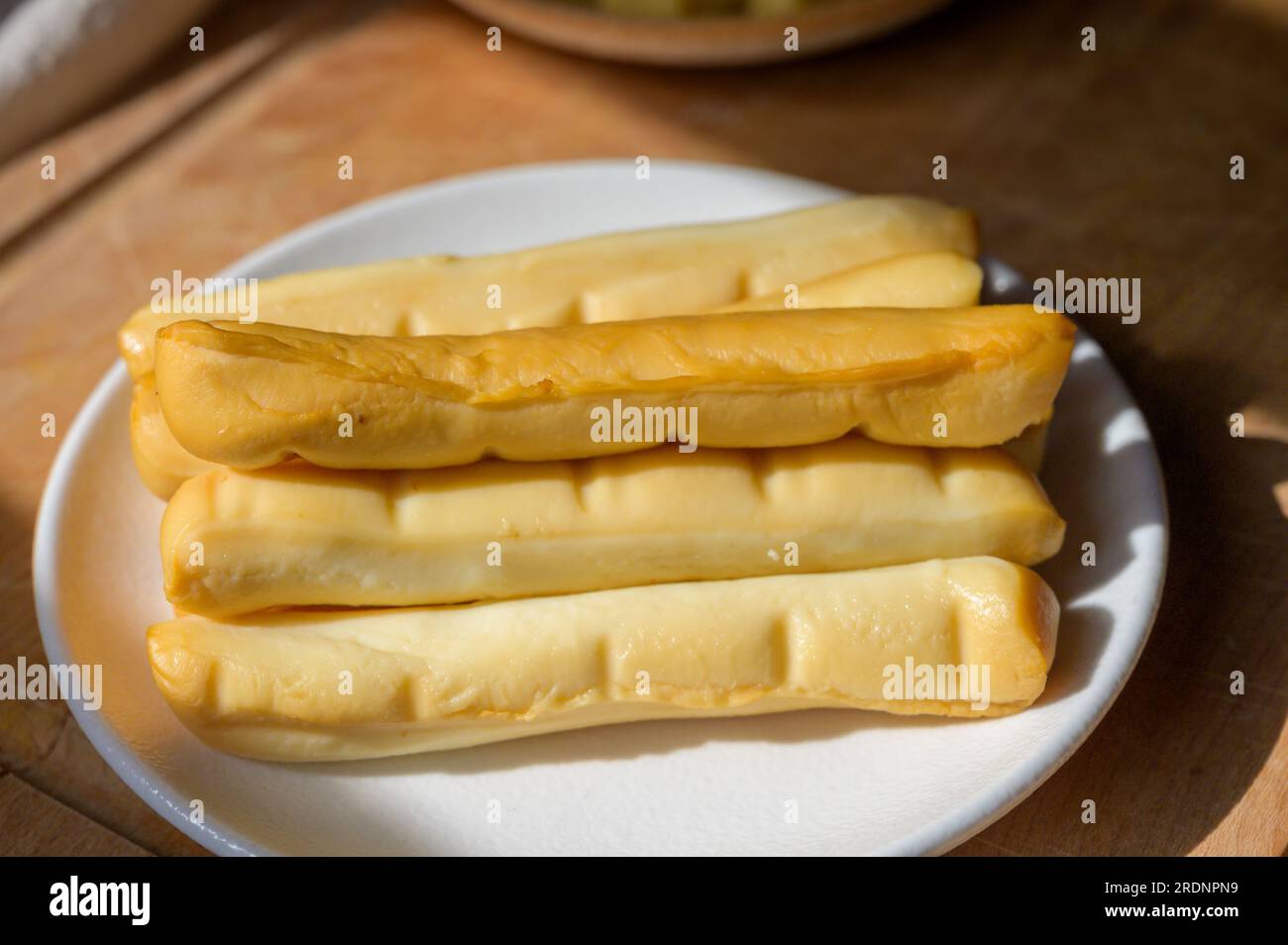 Collezione di formaggi, caciocavallo italiano affumicato giallo o scamorza bastoncini pugliesi, gustoso spuntino Foto Stock