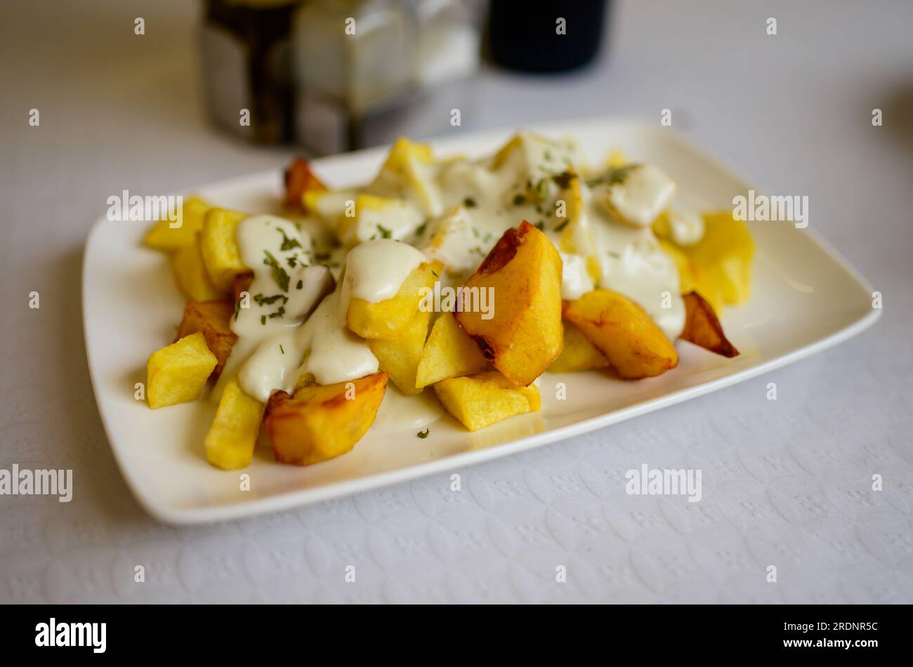 Patate arrosto in stile asturiano patatine fritte con formaggio fuso cabrales dal villaggio di Las Arenas, Asturias, Spagna Foto Stock