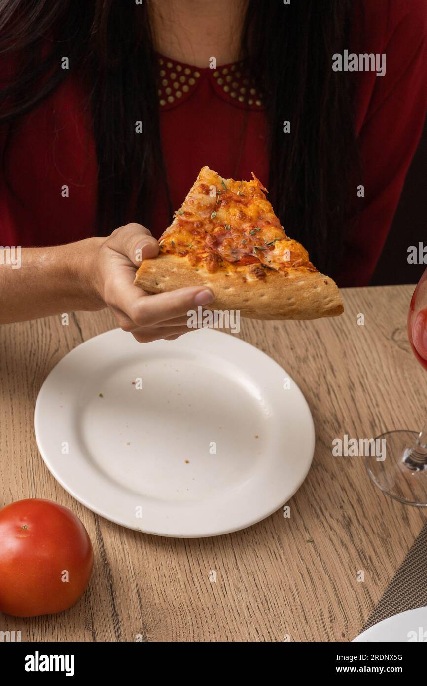 dettagli del cibo, mordere un pezzo di pizza, appetitosi fast food come carta da parati in studio, mangiare malsano, stile di vita Foto Stock