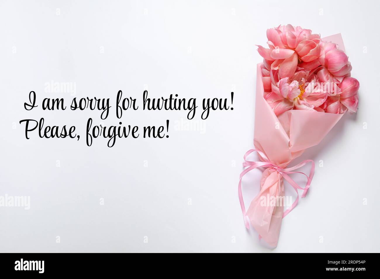 Messaggio sincero e spiacente e bouquet di fiori rosa su sfondo bianco, vista dall'alto Foto Stock