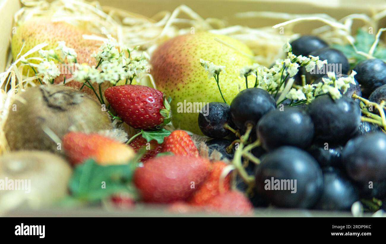 Concentrazione selettiva della composizione di vari frutti esotici isolati. I frutti sono come l'uva kiwi di pera e la fragola. Frutta deliziosa e matura Foto Stock