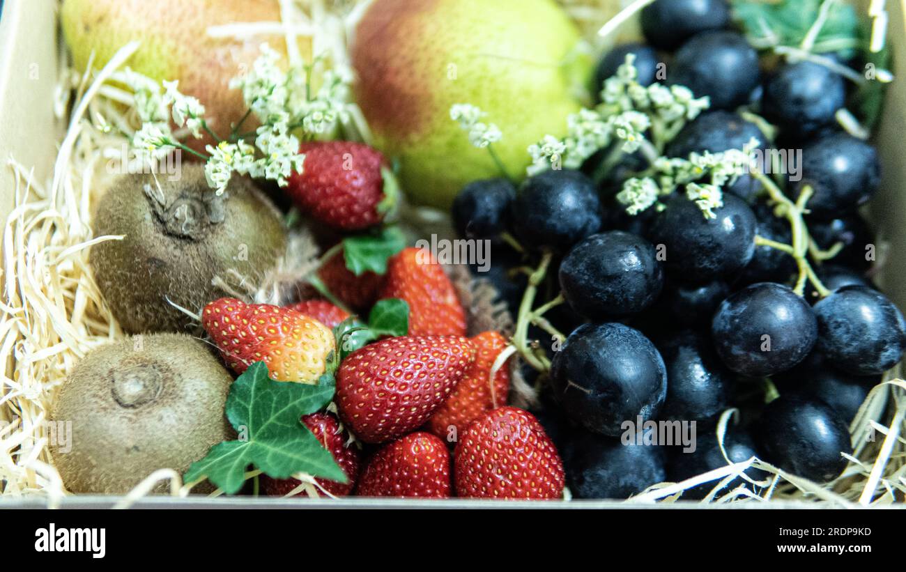 Concentrazione selettiva della composizione di vari frutti esotici isolati. I frutti sono come l'uva kiwi di pera e la fragola. Frutta deliziosa e matura Foto Stock