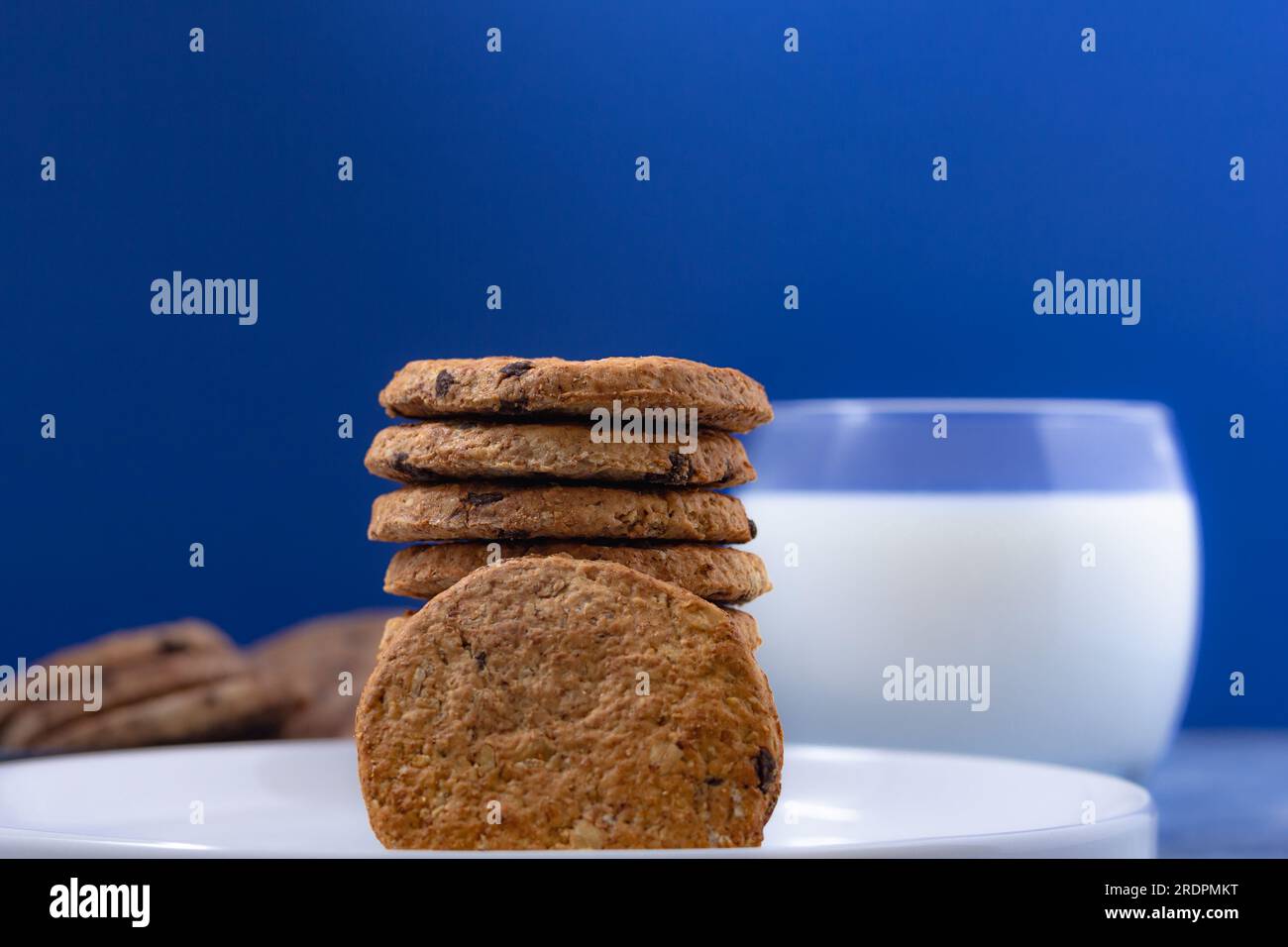 Biscotti in pila con bicchiere di latte fresco su sfondo blu (famosa marca americana di biscotti) Foto Stock