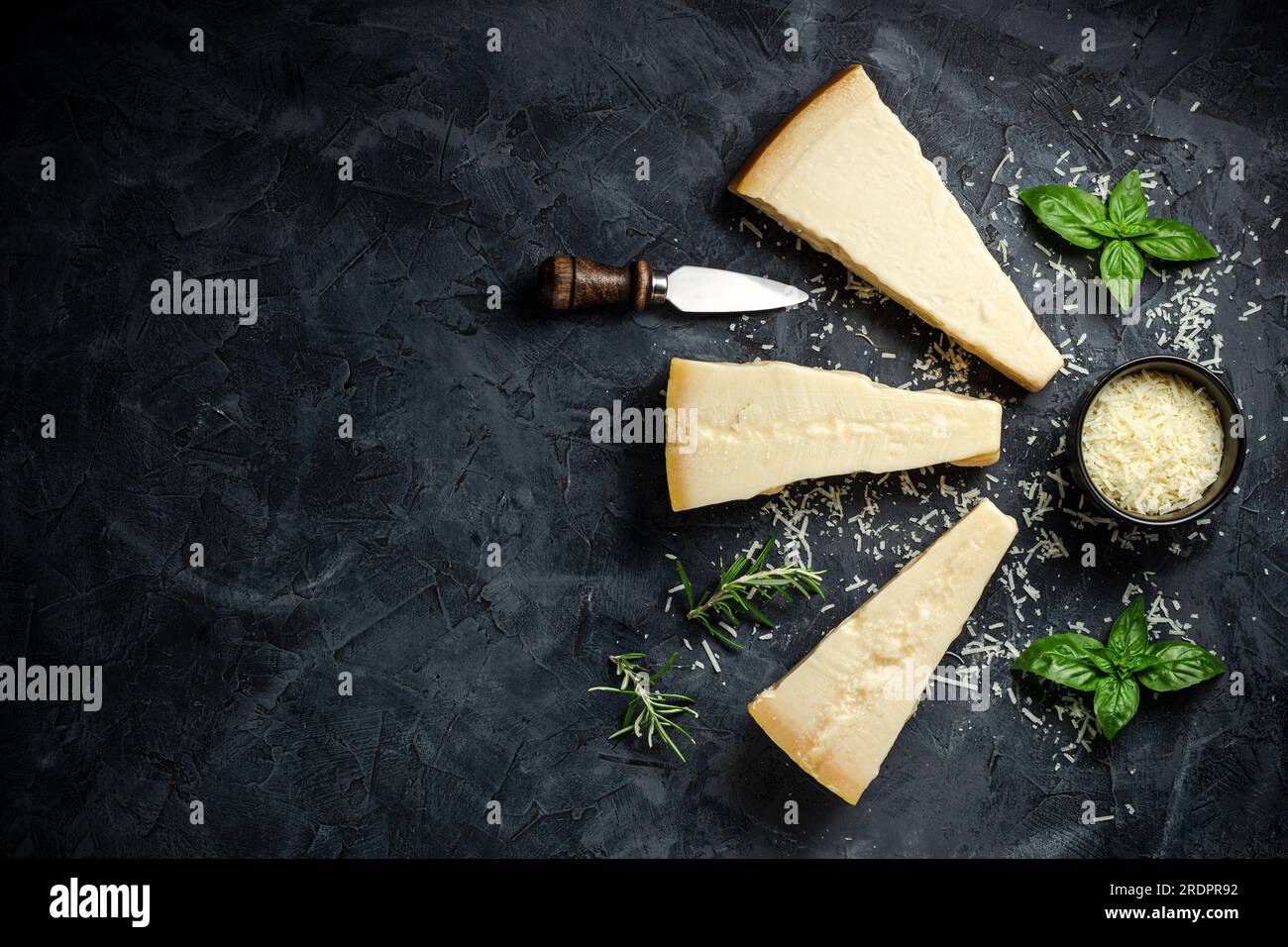 Parmigiano. Formaggio duro su fondo scuro. banner, menu, posizione ricetta per il testo, vista dall'alto. Foto Stock