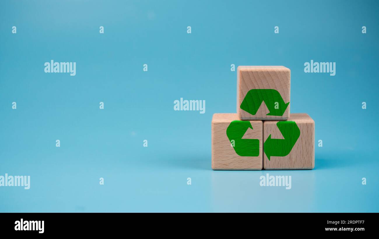 Blocchi di legno impilati con simbolo verde di riciclaggio. Concetto di riciclaggio. Foto Stock