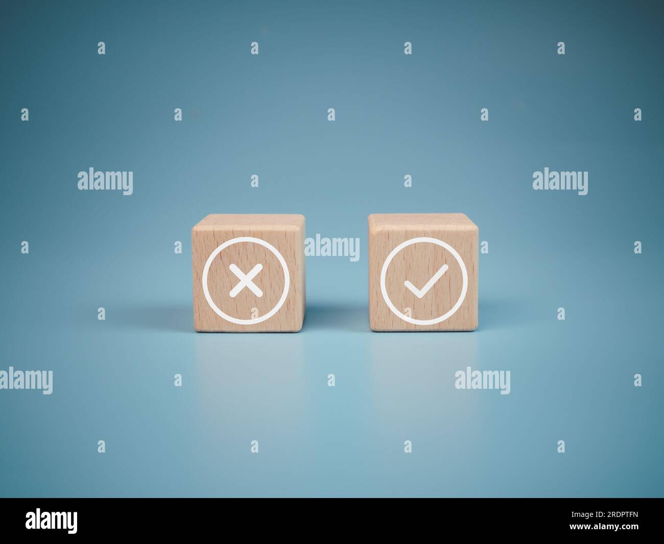 Blocchi di legno con simboli errati e corretti su sfondo azzurro. Foto Stock