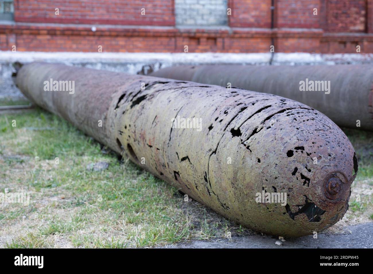 Vecchi siluri o bombe abbandonati si trovano di fronte al Museo della prigione di Karosta, presso l'ex base navale russa imperiale e sovietica sul Mar Baltico Foto Stock