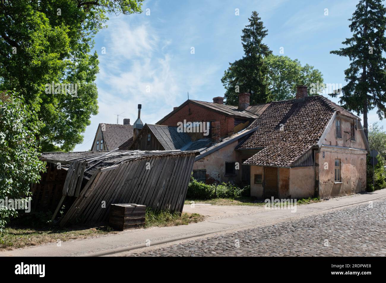 Via con vecchia casa fatiscente nella città vecchia di Kuldīga in lettone Foto Stock