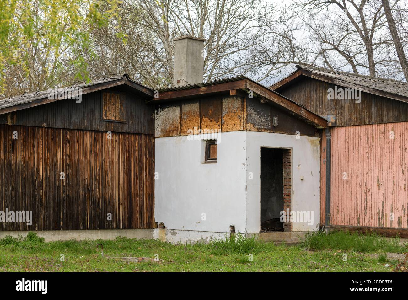 Vecchi capannoni abbandonati con facciate e tetti usurati Foto Stock
