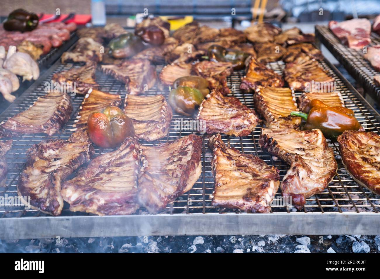 Vista della carne con peperoni arrostiti su un grande grill Foto Stock