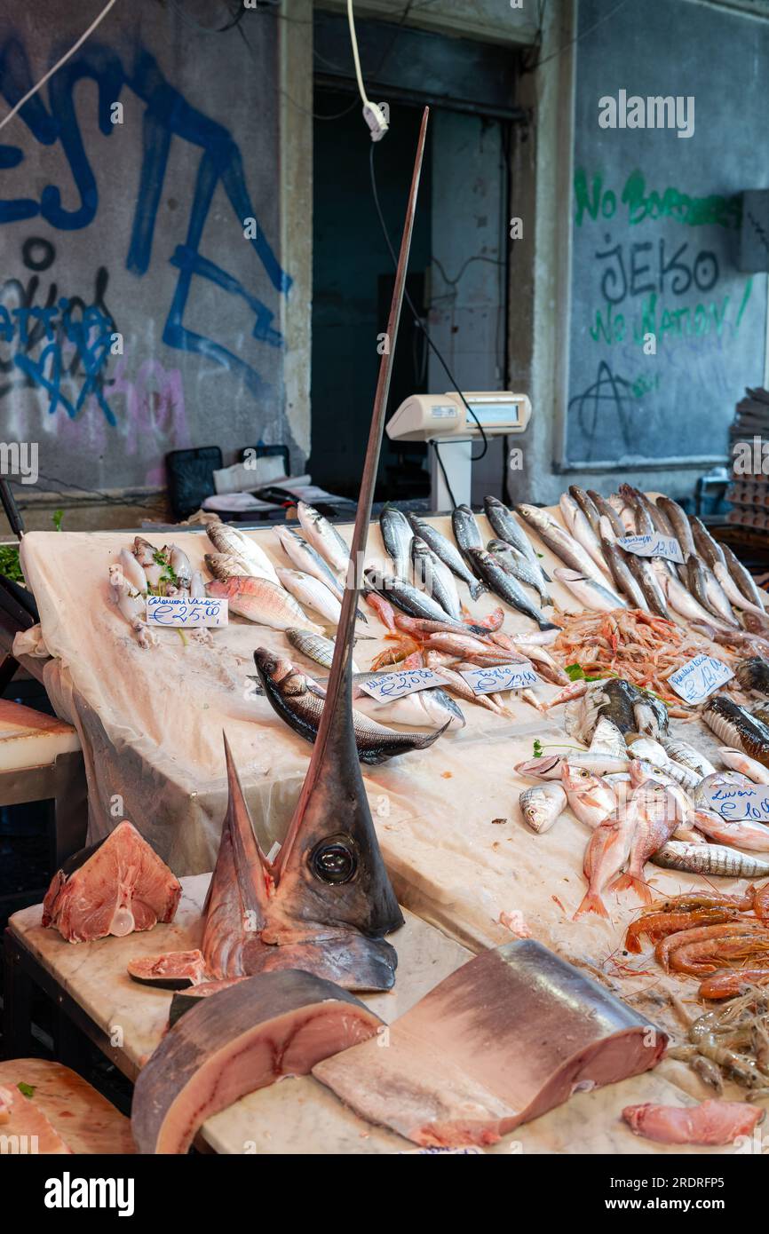 Pesce fresco con testa di pesce spada grande venduto in un mercato ittico italiano in Sicilia Foto Stock