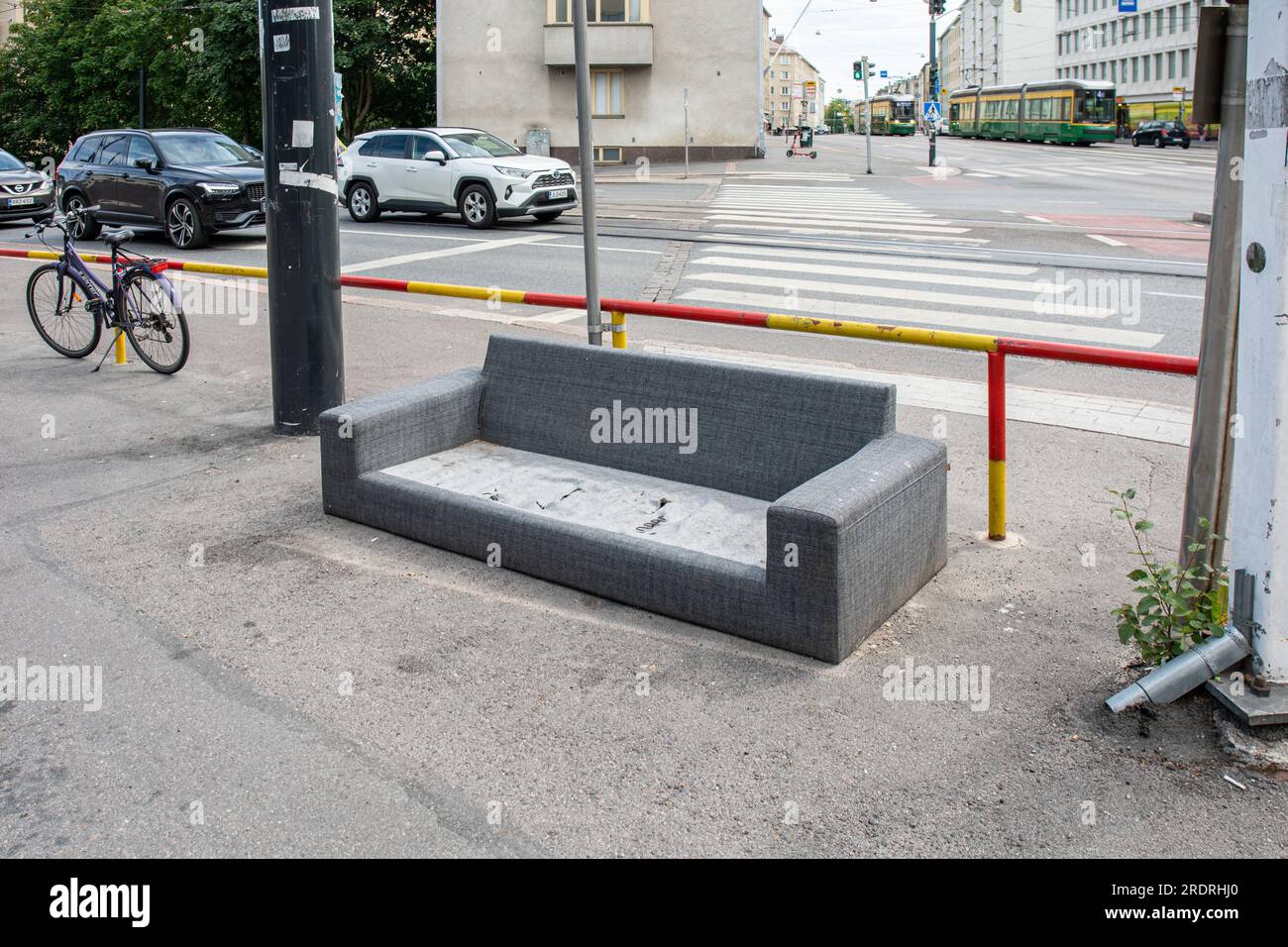 Abbandonato vecchio divano nell'angolo tra Mannerheimintie e Reijolankatu nel distretto di Taka-Töölö di Helsinki, Finlandia Foto Stock