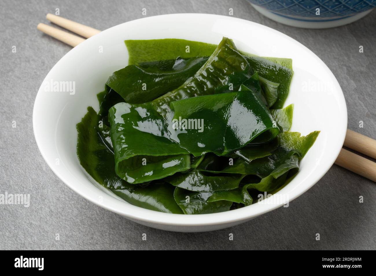 Ciotola con wakame verde imbevuto da vicino come ingrediente Foto Stock