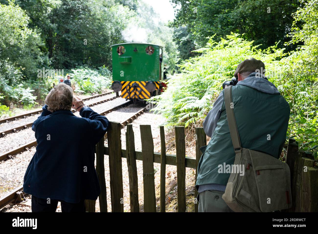 Appassionati di ferrovie che fotografano un motore a vapore su una ferrovia inglese conservata Foto Stock