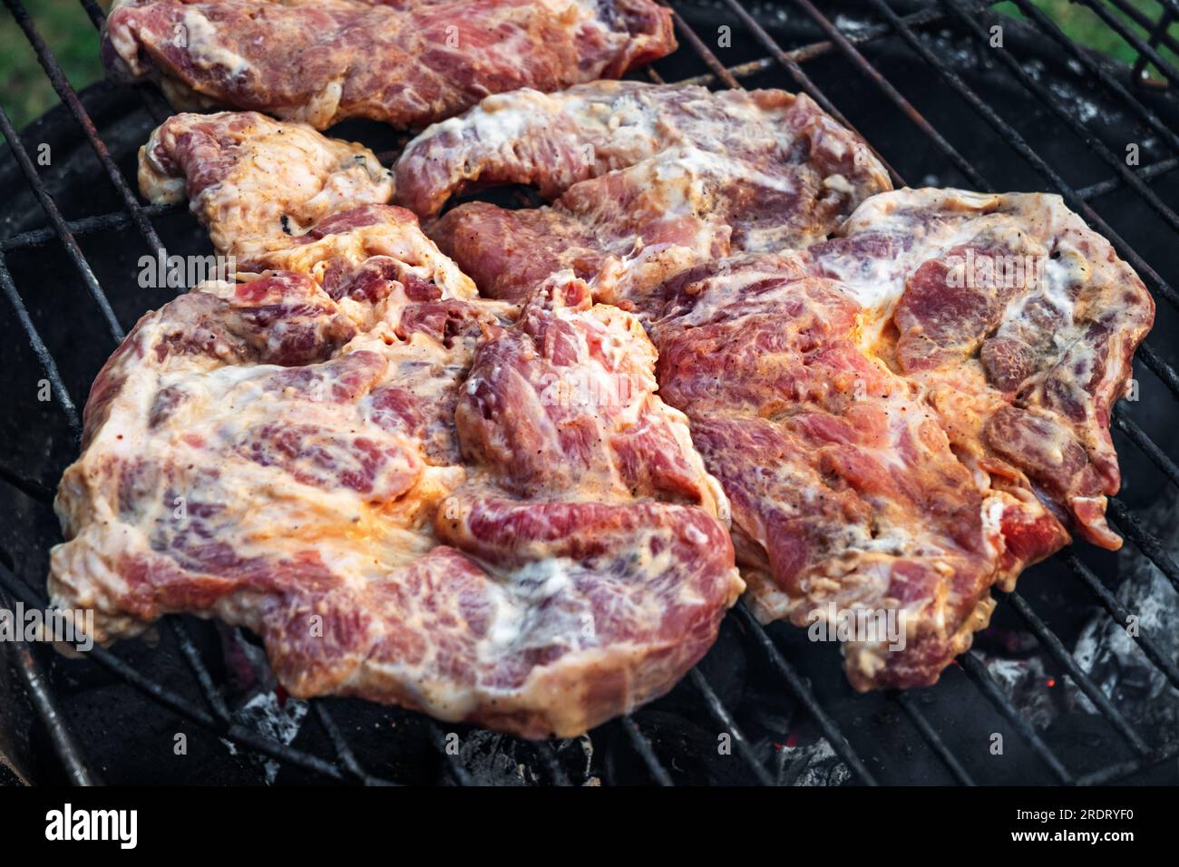 Bistecca di maiale marinata cruda tagliata su griglia. Foto Stock