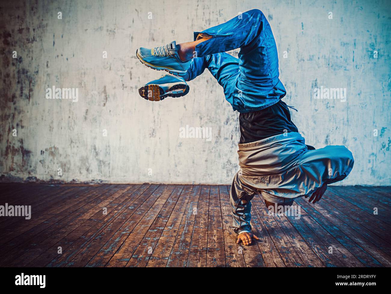 Giovane uomo break dancing su sfondo a parete Foto Stock