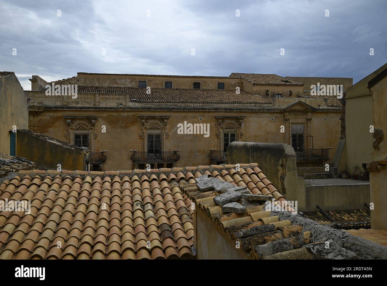 Paesaggio urbano con vista panoramica di Palazzo Landolina, come visto su antichi tetti di tegole di argilla a noto in Sicilia, Italia. Foto Stock