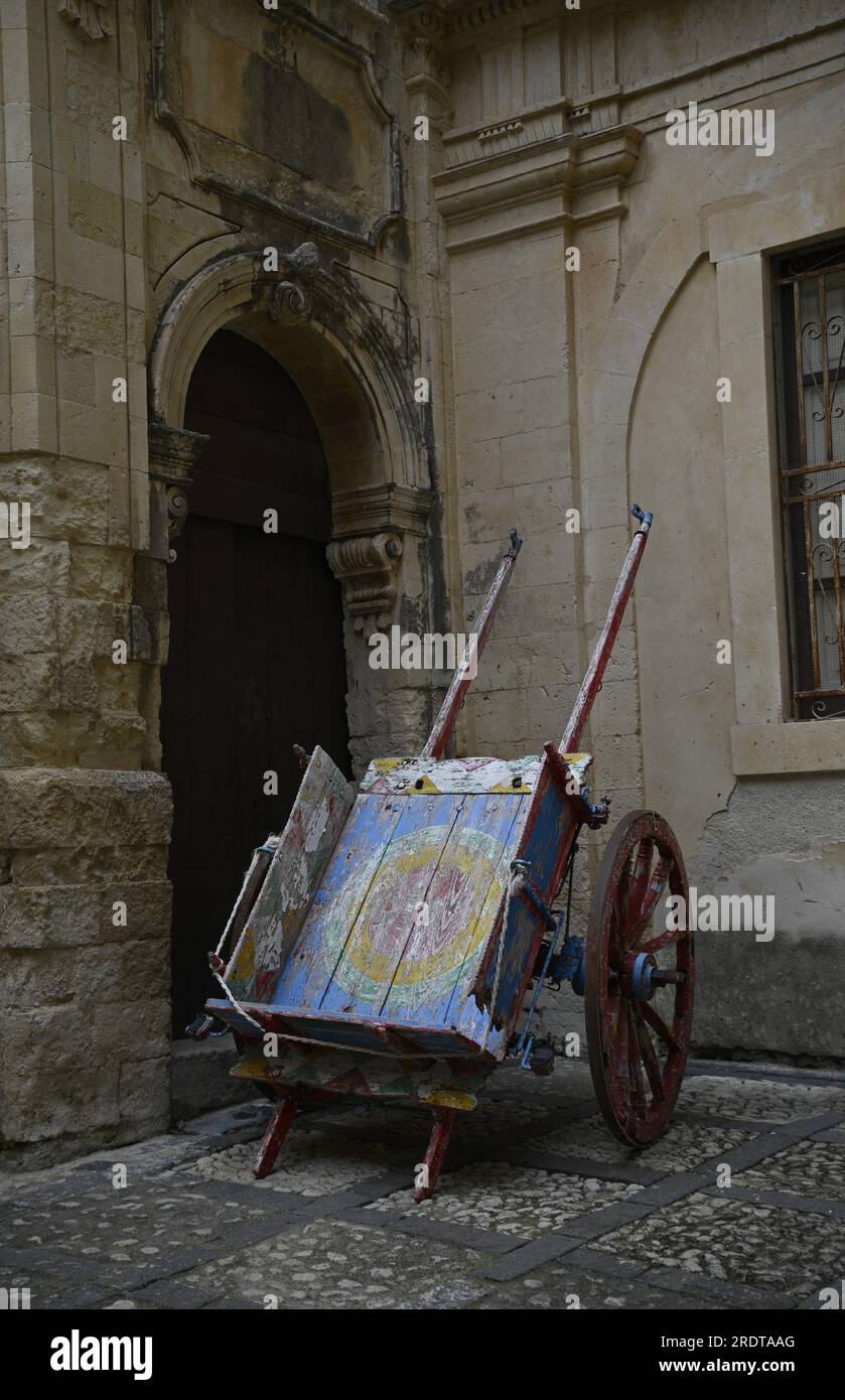 Carrettu Sicilianu tradizionale in legno con iconografia folcloristica siciliana nel cortile di Palazzo Landolina a noto, Sicilia. Foto Stock