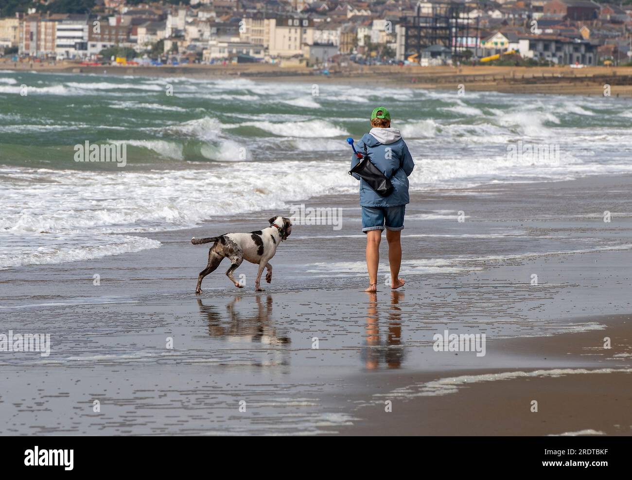 giovane donna che cammina in spiaggia Foto Stock