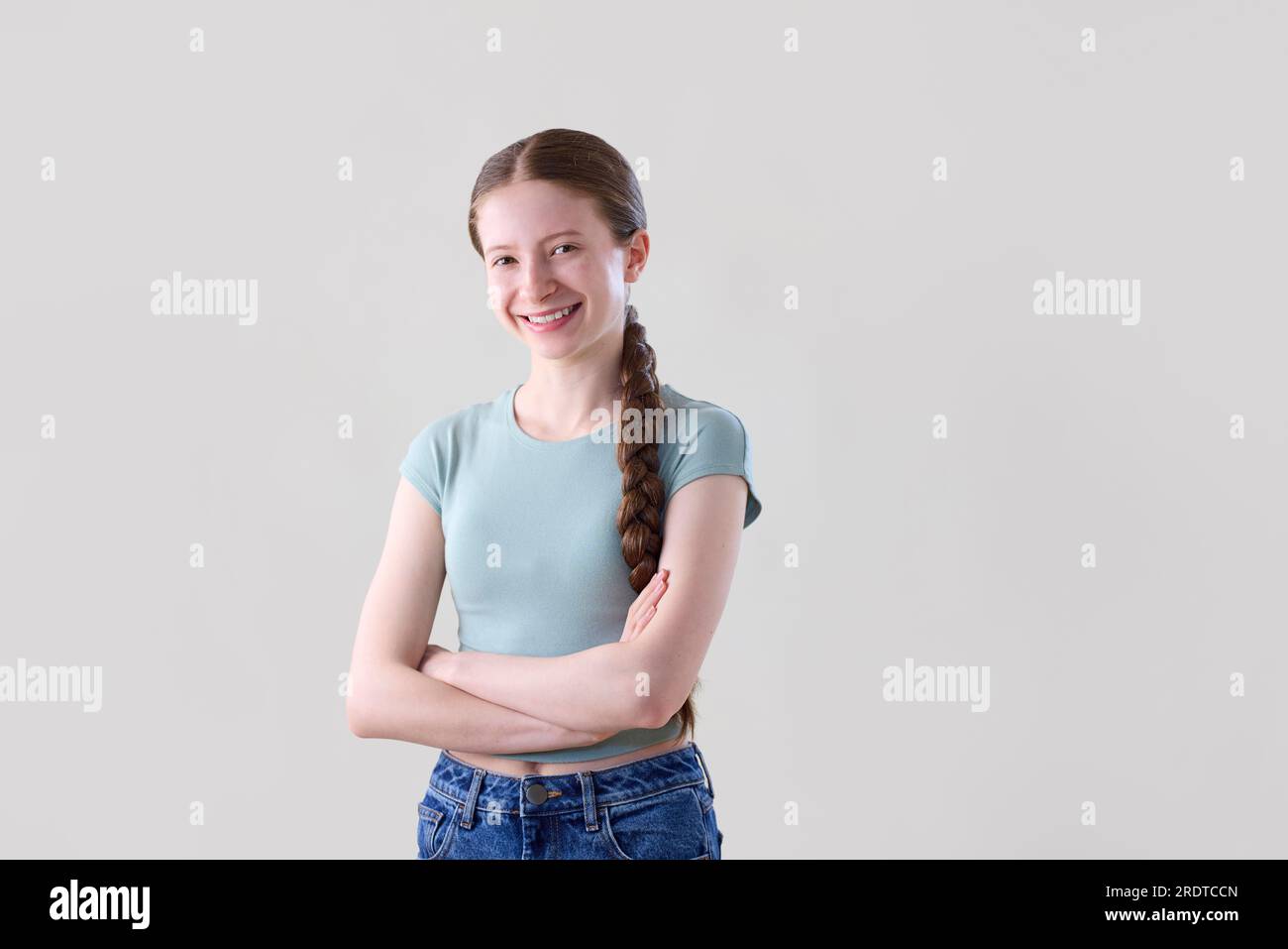 Ritratto in studio di una ragazza adolescente felice sorridente e sicura di sé che guarda la fotocamera Foto Stock