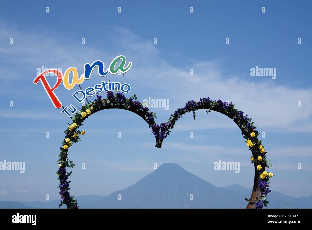Punto a forma di cuore per scattare foto con Pana il cartello della tua destinazione nel lago atitlan e il vulcano in lontananza a Panajachel, Guatemala Foto Stock