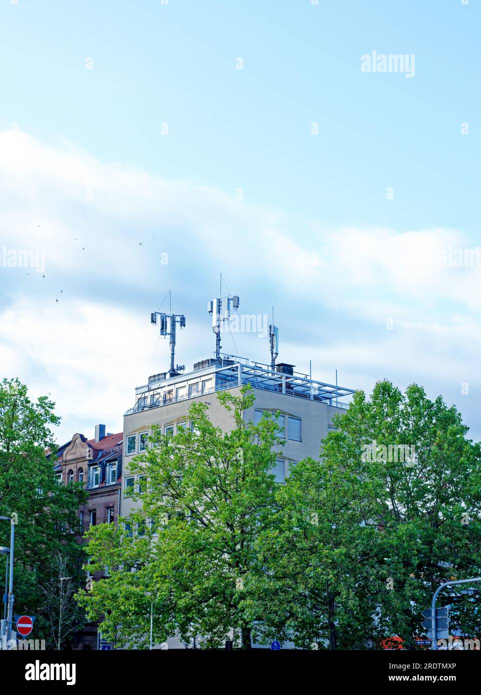 Comunicazione: Diverse antenne per telefoni cellulari sul tetto di un edificio Foto Stock