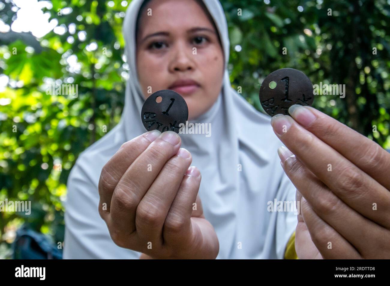 I venditori mostrano patatine di cocco che valgono una sola conchiglia come mezzo di pagamento per sostituire il denaro in un festival di spuntini del villaggio Foto Stock