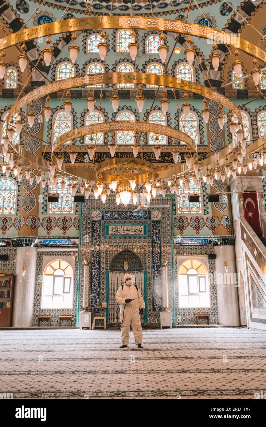 I lavoratori spruzzano disinfettante nelle moschee come parte delle misure preventive contro la diffusione del coronavirus COVID-19. Foto Stock