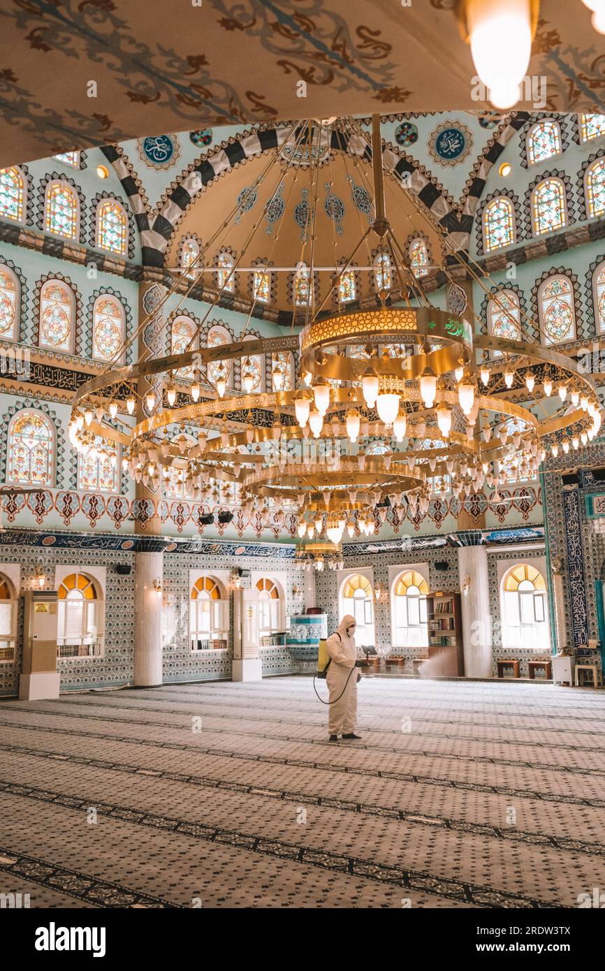 I lavoratori spruzzano disinfettante nelle moschee come parte delle misure preventive contro la diffusione del coronavirus COVID-19. Foto Stock