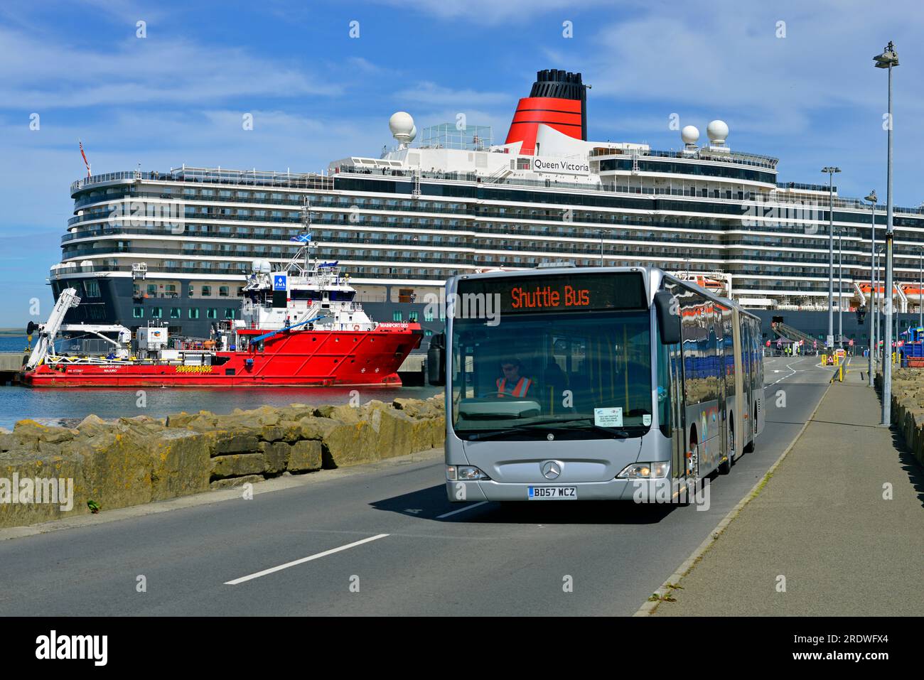 L'autobus navetta per le navi da crociera viaggia attraverso la strada rialzata a Kirkwall sull'Isola delle Orcadi. L'autobus trasporta passeggeri dalla Queen Victoria di Cunard. Foto Stock